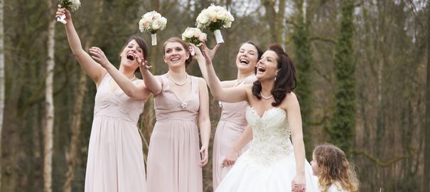 bridesmaids dressed the same way with bouquets smaller than that of the bride's